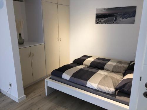 um quarto com uma cama e armários em preto e branco em Ferienwohnung Poppelreiter em Solingen