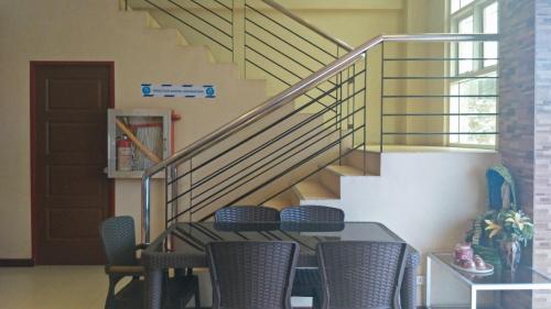 a table and chairs in a room with a staircase at RedDoorz near Talisay District Hospital in Candulawan