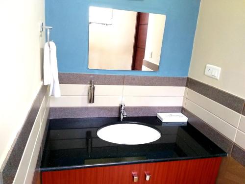 a bathroom with a sink and a mirror at Laurel Heights Resort Idukki in Idukki