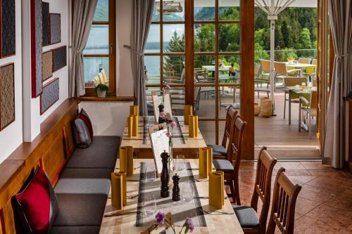 een restaurant met tafels en stoelen en uitzicht op een patio bij MONDI Hotel am Grundlsee in Grundlsee