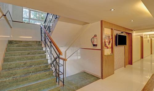 Una televisión o centro de entretenimiento en Treebo Vikrant Residency
