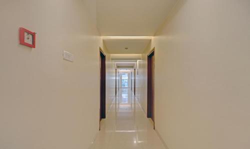 un pasillo con paredes blancas y suelo de baldosa blanca en Treebo Vikrant Residency, en Pune