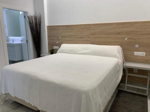 ムルシアにあるCasa de invitados con piscina privada y WIFIの大きな白いベッドと机のある寝室