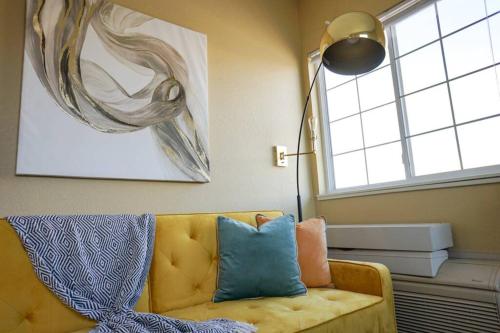 ein Wohnzimmer mit einem gelben Sofa und einem Fenster in der Unterkunft Sleepover 1BD 1BA Downtown Wichita Apartments in Wichita