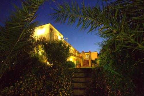 a house with lights on the side of it at night at Torre Archirafi Resort in Riposto