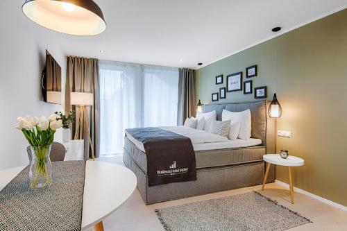 a bedroom with a king sized bed and a table at Business Hotel Maier - kontaktloser Check-in in Götzis