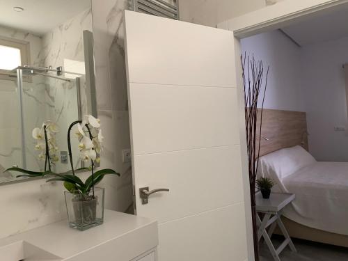 uma casa de banho branca com um chuveiro e uma cama em Casa de invitados con piscina privada y WIFI em Múrcia