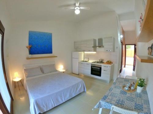 a white bedroom with a bed and a kitchen at Ammiraglio in Campese