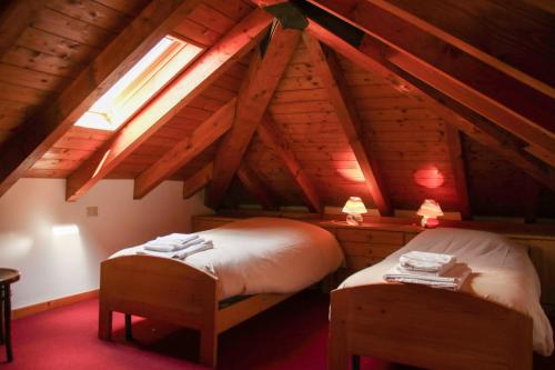 アジアーゴにあるLocanda Aurora-garnìのベッドルーム(ベッド2台付)が備わる屋根裏部屋です。