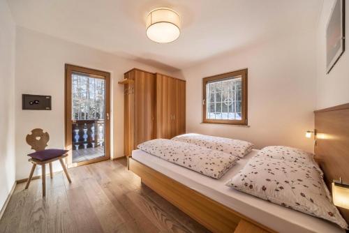 - une chambre avec un lit, une chaise et une fenêtre dans l'établissement Ferienwohnung Hirzer Edelweiss, à Avelengo