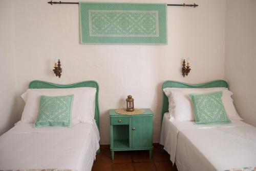 duas camas sentadas uma ao lado da outra com uma mesa entre elas em Villa Bados 6 - Klodge em Olbia
