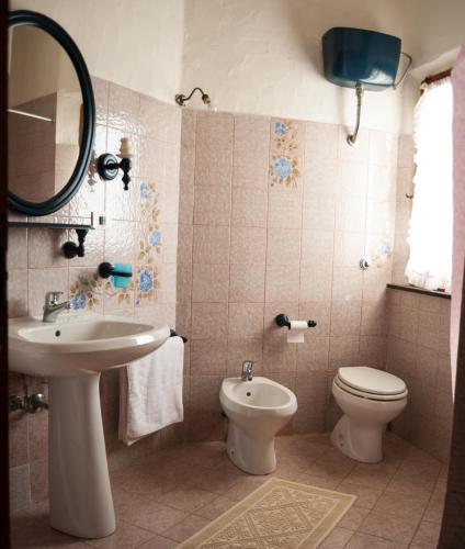 a bathroom with a sink and a toilet and a mirror at Villa Bados 6 - Klodge in Olbia