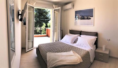 Schlafzimmer mit einem Bett und einer Tür zu einem Balkon in der Unterkunft Residenza VerdeMare in Misano Adriatico