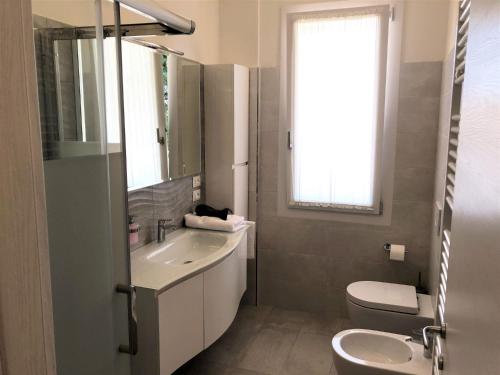 ein Bad mit einem Waschbecken, einem WC und einem Fenster in der Unterkunft Residenza VerdeMare in Misano Adriatico