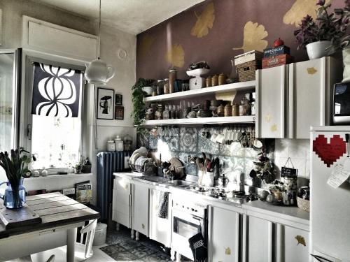 een keuken met witte kasten en een fornuis bij RaMaya, casa d'artista in Biella