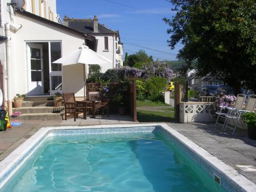 a swimming pool in front of a house at Saffron House in Combe Martin