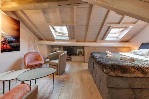 een kamer met een bed en een woonkamer met ramen bij The Attic - Ideally located in the old town in Annecy