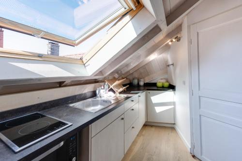 Il comprend une petite cuisine avec un évier et une lucarne. dans l'établissement The Attic - Ideally located in the old town, à Annecy