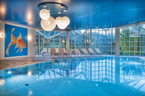 グルントルゼーにあるMONDI Chalets am Grundlseeのホテル内のプール(椅子、照明付)