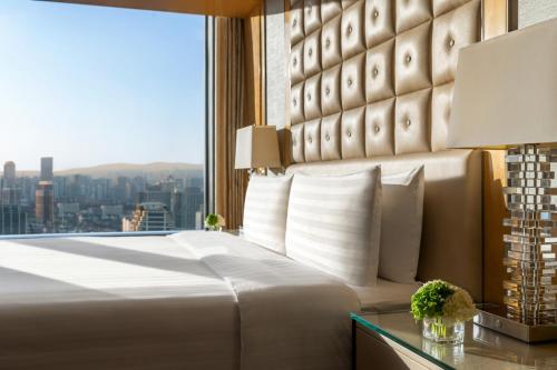 a bedroom with a large bed and a large window at Shangri-La Nanjing in Nanjing