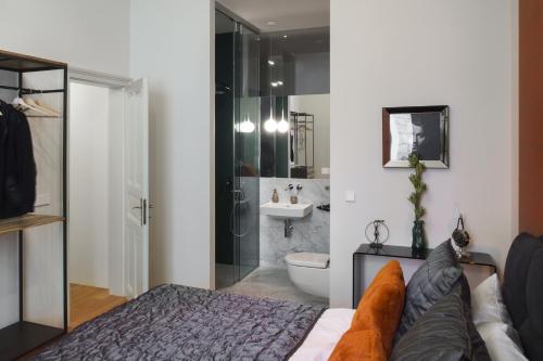 ein Schlafzimmer mit einem Bett und ein Badezimmer mit einer Dusche in der Unterkunft MN6 Luxury Suites by Adrez in Prag