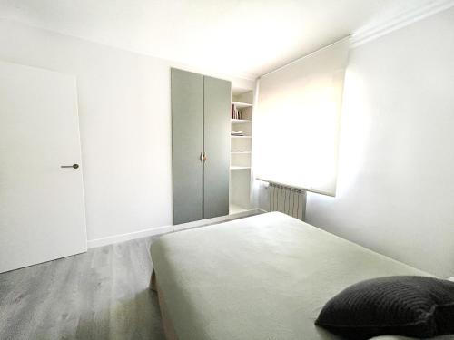 Dormitorio blanco con cama y armario en Luxury Cercas Bajas Vitoria, en Vitoria-Gasteiz