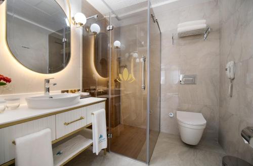 a bathroom with a shower and a sink and a toilet at Elysium Green Suites in Antalya