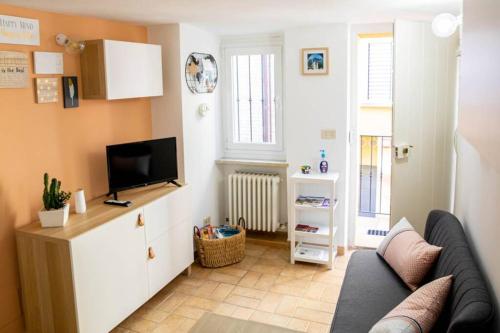 a living room with a couch and a tv at La Casetta - Casa Indipendente nel centro storico in Fermo