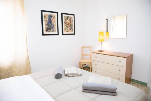 a white bedroom with a bed and a dresser at La Casetta - Casa Indipendente nel centro storico in Fermo