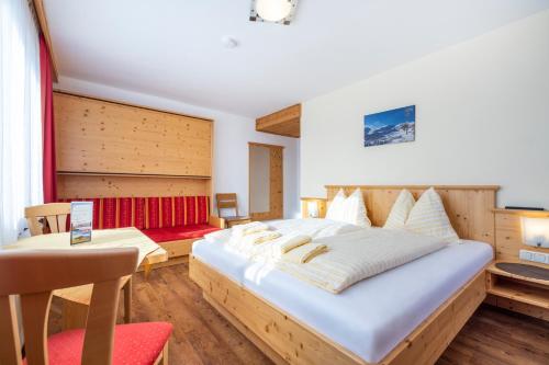 a bedroom with a large bed and a table at Gasthof Jandlalm in Flachau