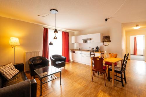 a living room with a table and a kitchen at Apparthotel Bad Schandau by STEIGER Hotels in Bad Schandau