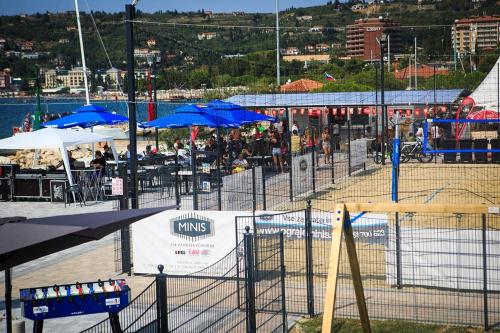 a group of people sitting at tables under umbrellas at Apartment Bonaca in Portorož