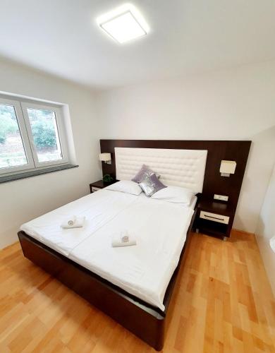 a bedroom with a large bed with white sheets at Apartment Bonaca in Portorož