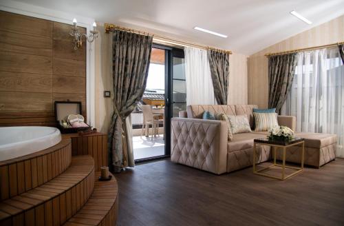 a bathroom with a tub and a chair and a couch at Elysium Green Suites in Antalya