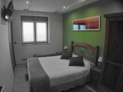 a bedroom with a large bed with green walls at Iturritxo Landetxea in Donostia-San Sebastián