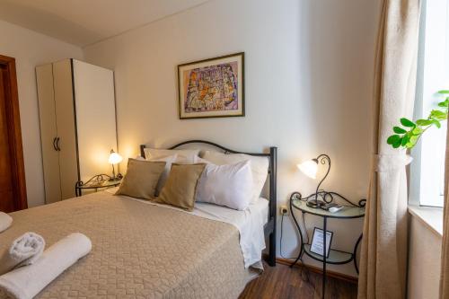 1 dormitorio con 1 cama, 2 lámparas y ventana en Katarina Old town, en Dubrovnik