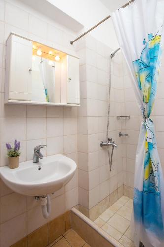 a bathroom with a sink and a shower at Kelly's Beach House 1 in Gennadi