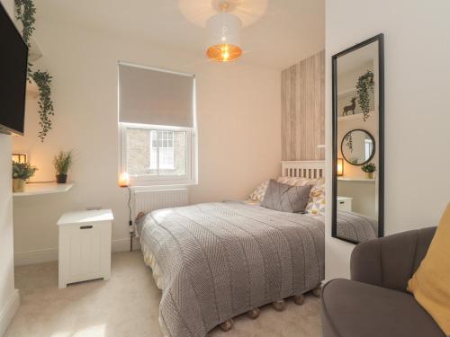 une petite chambre avec un lit et un miroir dans l'établissement Hope Cottage, à Hythe