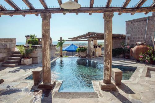 a swimming pool in a backyard with a pergola at Les Maisons De Cappadoce in Uçhisar