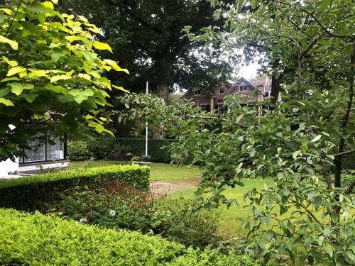 a garden with a house in the background at Modern Palace Emma Staete in Baarn