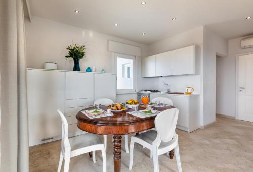 een keuken en eetkamer met een houten tafel en stoelen bij Viareggio Suite - Sea view apartment in Viareggio