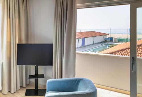 a room with a blue chair and a large window at Viareggio Suite - Sea view apartment in Viareggio