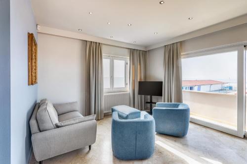 een woonkamer met 2 stoelen en een bank bij Viareggio Suite - Sea view apartment in Viareggio