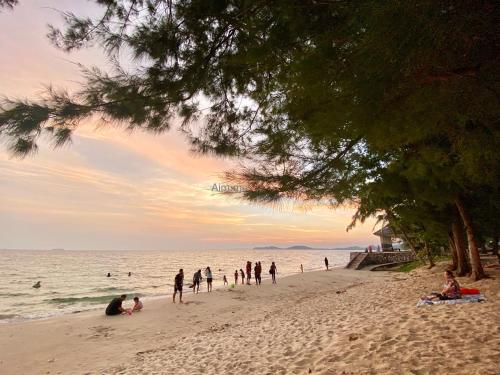 a group of people on a beach with the ocean at Mantra Beach Condominium Suite - Mae Phim in Ban Tha Fat