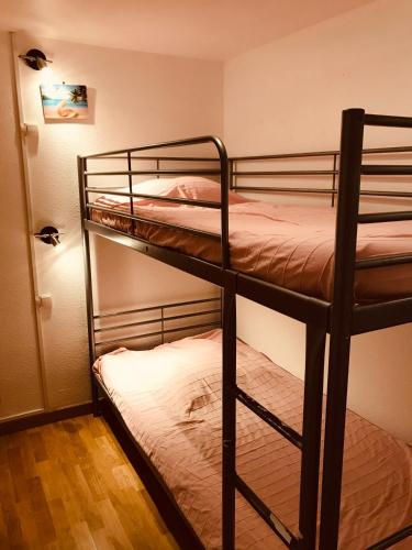 Ce dortoir comprend 2 lits superposés et une porte. dans l'établissement Pied à terre à deux pas de la mer, des commodités, à Saint-Jean-de-Monts