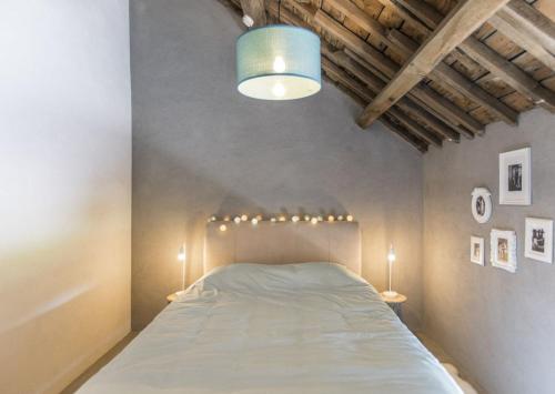 a bedroom with a bed with a blue light above it at La Grange de Victor in Léglise