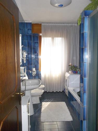 a bathroom with two toilets and a sink and a window at B&B da Lori in Tirano