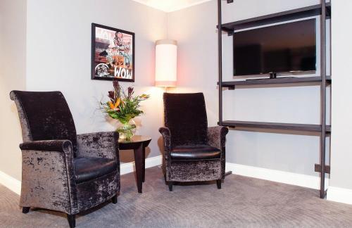 a room with two chairs and a table with a tv at Malmaison Edinburgh in Edinburgh