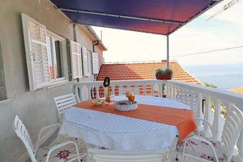 Biały stół i krzesła na balkonie w obiekcie Apartments Villa Marijana w mieście Prižba