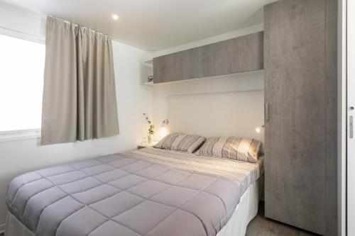 Un dormitorio con una cama grande y una ventana en Camping Village Riviera, en Numana